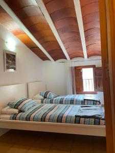 セエヒンにあるCehegin Old Town Houseの木製天井のベッドルーム1室(ベッド2台付)