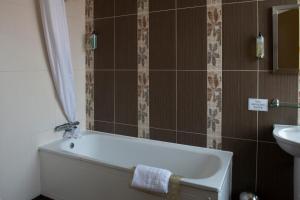 a bathroom with a bath tub and a sink at The Romany Rye Wetherspoon in East Dereham