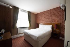 a hotel room with a bed and a window at The Romany Rye Wetherspoon in East Dereham