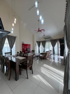 een woonkamer met een tafel en stoelen en een bank bij D JANNAH HOMESTAY SERI ISKANDAR PERAK in Seri Iskandar