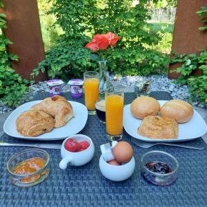 a table with plates of breakfast foods and drinks at Le Spa du Cabanon: Cabanon de luxe avec Spa entièrement privatif in Aye