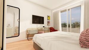 Habitación de hotel con cama, escritorio y TV. en Hotel Foners, en Playa de Palma