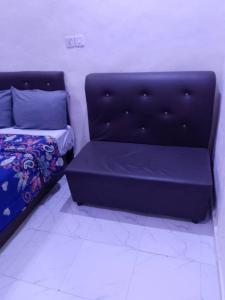 JEFFOSA Hotel & Suites في لاغوس: غرفة نوم مع أريكة وسرير في غرفة