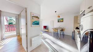 a kitchen and a living room with a table at Haut Saint Georges - Un emplacement exceptionnel au centre-ville et au calme à quelques pas du lac marin in Soorts-Hossegor