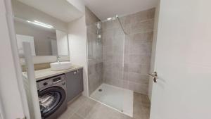 a bathroom with a washing machine and a sink at Haut Saint Georges - Un emplacement exceptionnel au centre-ville et au calme à quelques pas du lac marin in Soorts-Hossegor