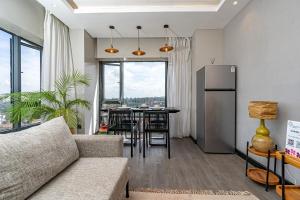a living room with a couch and a table at Escada Studio & 2-bedroom, Rooftop Lounge & Restaurant, Swimming Pool, Gym, Workspace, Wonderiss Properties Westlands Living in Nairobi