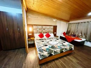 Hotel Ganga Near Mall Road في شيملا: غرفة نوم بسرير كبير وسقف خشبي