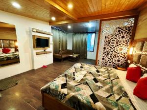 Hotel Ganga Near Mall Road في شيملا: غرفة نوم فيها سرير وتلفزيون