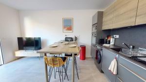 a kitchen with a table and chairs in a room at TERRASSES SAINT GEORGES - Un emplacement exceptionnel au centre-ville et au calme à quelques pas du lac marin in Soorts-Hossegor