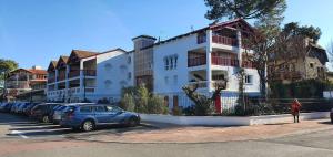 a parking lot with cars parked in front of a building at TERRASSES SAINT GEORGES - Un emplacement exceptionnel au centre-ville et au calme à quelques pas du lac marin in Soorts-Hossegor +10 photos