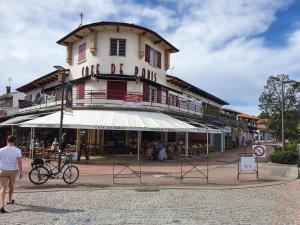 a building on a street with a bicycle in front of it at TERRASSES SAINT GEORGES - Un emplacement exceptionnel au centre-ville et au calme à quelques pas du lac marin in Soorts-Hossegor