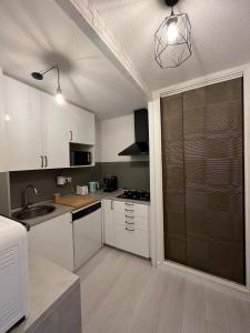 uma cozinha com armários brancos e uma porta de vidro deslizante em Un,Deux,Trois...Soleil em Le Pradet