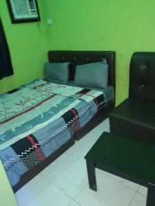 JEFFOSA Hotel & Suites في لاغوس: غرفة نوم بسرير واريكة وطاولة