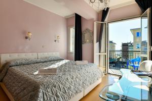 1 dormitorio con cama y mesa de cristal en HOTEL BLUMARIN en Lido di Jesolo