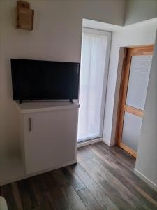 Logement avec accès terrasse في Mazières-en-Gâtine: غرفة معيشة مع تلفزيون بشاشة مسطحة على خزانة