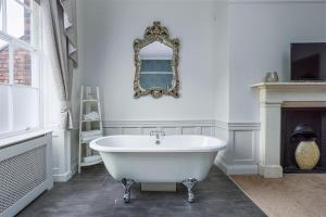 a white bath tub in a bathroom with a fireplace at The Pied Bull in Chester +121 photos