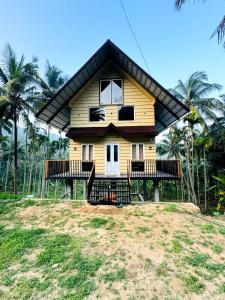 Casa amarilla pequeña con balcón en la playa en Nandhanam Homestay, en Palakkad