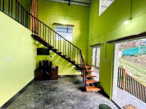 un pasillo con una escalera en una pared verde en Nandhanam Homestay, en Palakkad