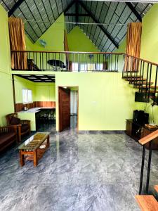 Habitación grande con escalera, mesa y sillas. en Nandhanam Homestay, en Palakkad