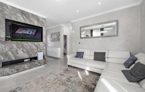 un soggiorno con un divano bianco e una TV di 3 Bedroom Amazing Home In Bilice a Bilice (Bilizze)
