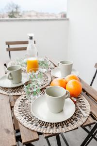 a table with plates and cups and oranges on it at StayEasy Argelati40 - Penthouse with 2 bedrooms, 2 bathrooms and terrace - Navigli in Milan