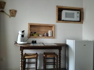 Logement avec accès terrasse في Mazières-en-Gâtine: طاولة مطبخ مع ميكروويف على الحائط بجانب ثلاجة