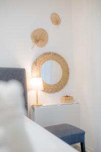 a bedroom with a mirror and a blue chair at Casa Romana Apartmanok Siófok By BLTN in Siófok