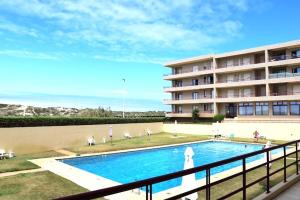 a swimming pool in front of a large building at Apartamento Mar & Sal in Mindelo