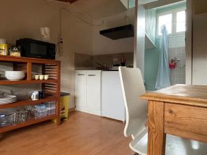une cuisine avec des placards blancs, une table et une fenêtre dans l'établissement Logement familial Etage privatif, à Bordeaux