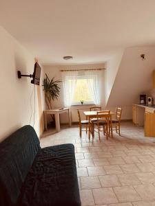 a living room with a couch and a table and chairs at Hotel | Restaurant | Forellenzucht in Burgen