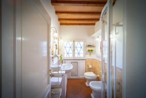 a bathroom with two sinks and a toilet and a window at Borgo Spedaletto 3 - Dolcevita Holiday in Grassina +42 photos