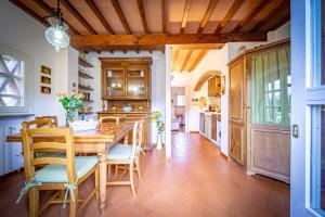 cocina con mesa de madera y sillas en Borgo Spedaletto 3 - Dolcevita Holiday, en Grassina