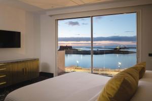 a bedroom with a large window with a view of the water at Blue Marina Suites - Boutique Apartments in Arrecife