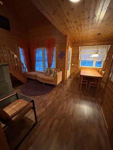una sala de estar con sofá y mesa en una cabaña en Kolazko Apartments, en Vuokatti