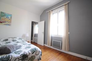1 dormitorio con cama y ventana grande en Le Domaine du petit Basque en Talence