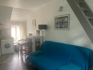 salon z niebieskim łóżkiem i stołem w obiekcie Logis côté Cour w mieście Varennes-lès-Narcy