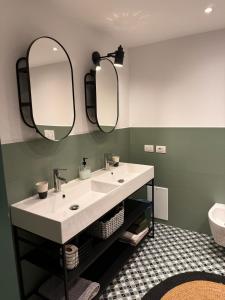 a bathroom with a sink and two mirrors at southsidehouse in Naples