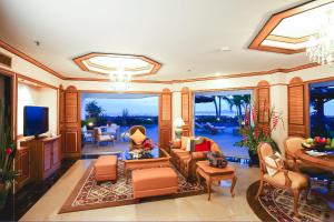 sala de estar con sofá y TV en Royal Cliff Grand Hotel Pattaya, en Pattaya South