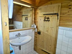 a bathroom with a sink and a wooden wall at Ponzaunerhof in Hebertsfelden