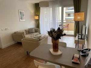 a living room with a table and a couch at Domitys Les Demoiselles - résidence séniors in Beaune