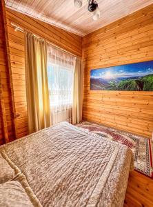 sypialnia z łóżkiem w drewnianym pokoju w obiekcie Домик в горах w mieście Besqaynar