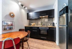 eine Küche mit einem Holztisch und einem Kühlschrank in der Unterkunft Appartement Charmant à Lille in Lille