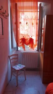 una sedia davanti a una finestra con una tenda arancione di Casa vacanze nel Parco Nazionale della Majella a Montenerodomo