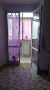 una porta aperta con tende rosa in una stanza di Casa vacanze nel Parco Nazionale della Majella a Montenerodomo