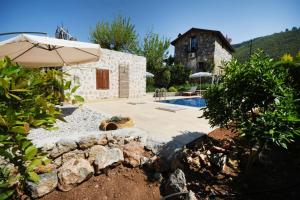 a house with a swimming pool and an umbrella at Kilim Kaya Villas in Kınalı
