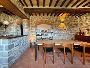 una sala da pranzo con tavolo e sedie in legno di Bio Agriturismo Il Vigno a Caprese Michelangelo