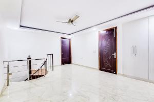a hallway with two doors and a ceiling fan at Hotel Satguru - Dwarka Mor Metro in New Delhi