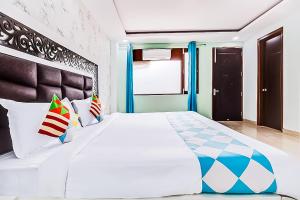 a bedroom with a large white bed with pillows at Hotel Satguru - Dwarka Mor Metro in New Delhi
