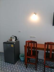 Cette chambre dispose d'une table, de deux chaises et d'un bureau. dans l'établissement Baan KaemSai, à Khao Lak