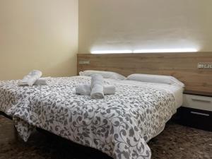 1 dormitorio con 1 cama con edredón blanco y negro en Vivienda Familiar junto Plaza Toros de Teruel, en Teruel